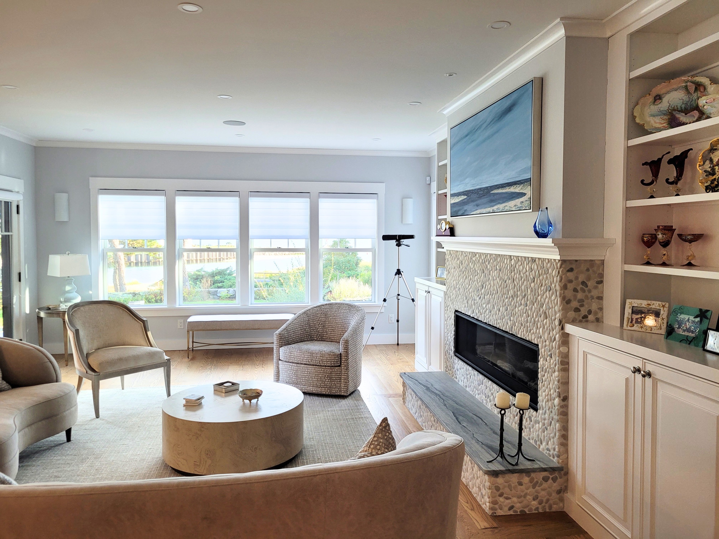 Finished Cape Cod living room with custom built-ins and a stone fireplace